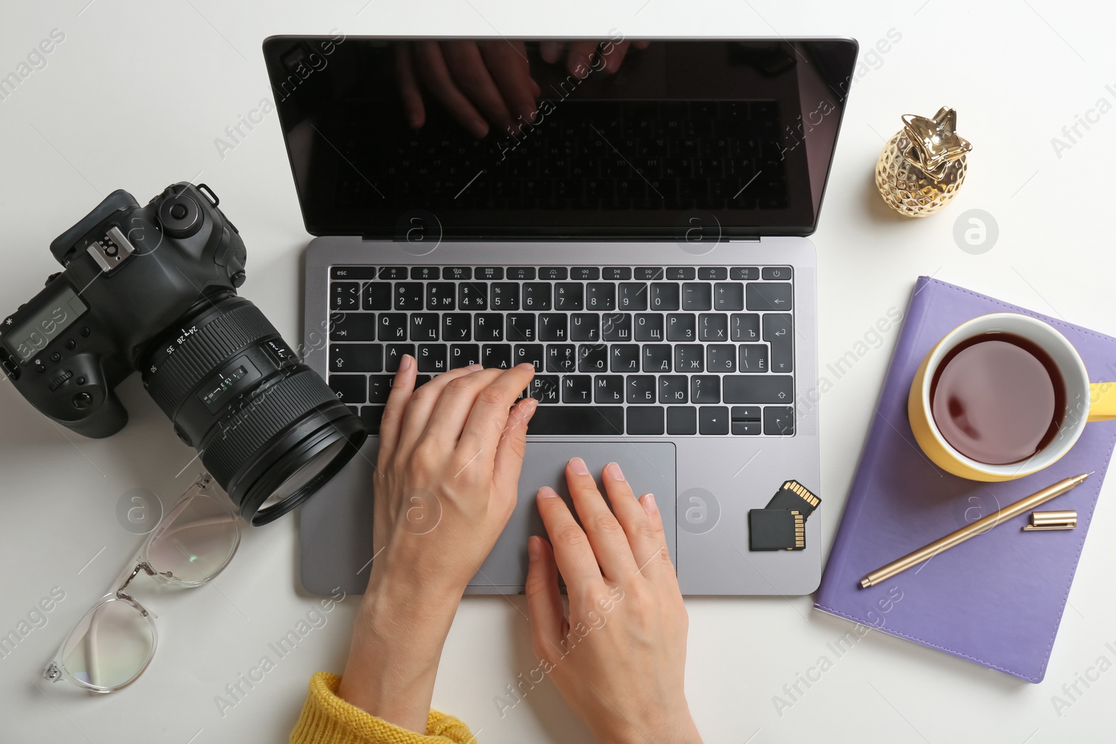 Photo of Female photographer using laptop at table, top view