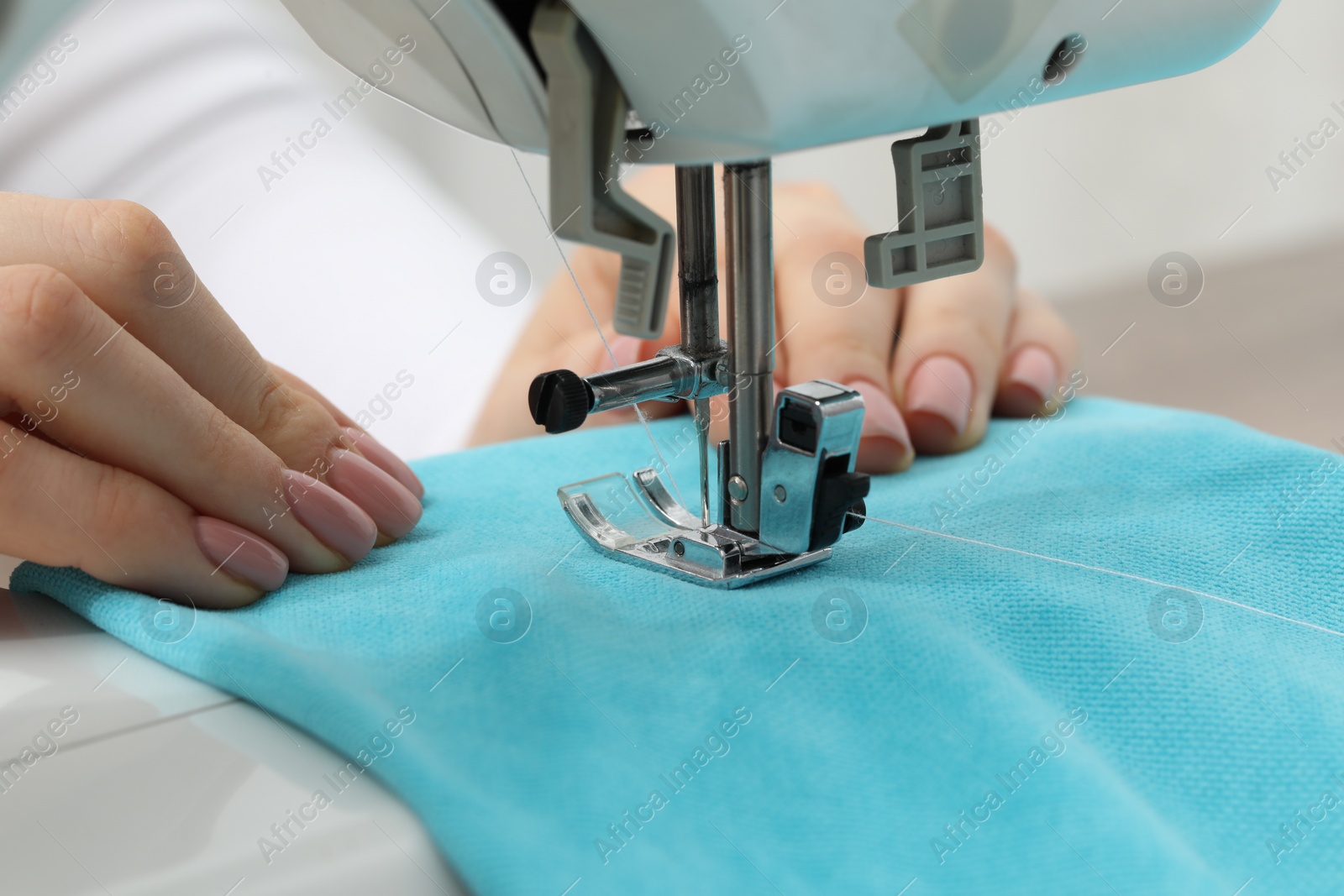 Photo of Seamstress working with sewing machine indoors, selective focus