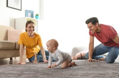Photo of Adorable little baby crawling near parents at home