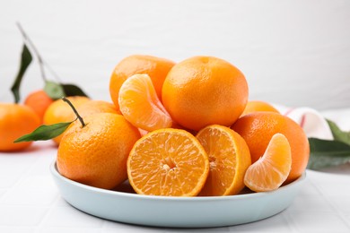 Fresh juicy tangerines on white tiled table