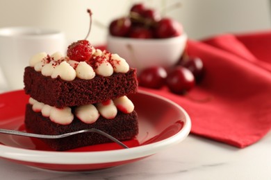 Piece of delicious red velvet cake and fork on white table, closeup. Space for text