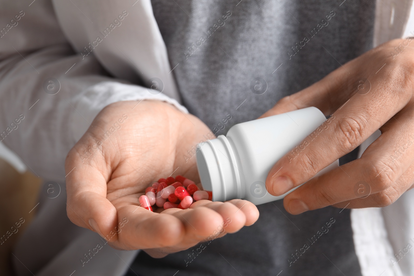 Photo of Man pouring pills from bottle, closeup view