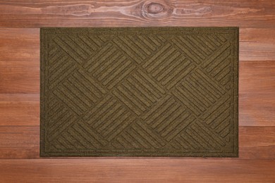 Photo of New clean door mat on wooden floor, top view
