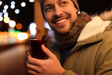 Happy man with mulled wine at winter fair