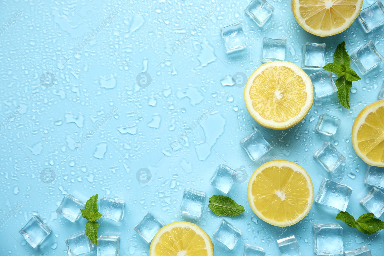 Photo of Ice cubes, mint and cut lemons on turquoise background, flat lay with space for text. Refreshing drink ingredients