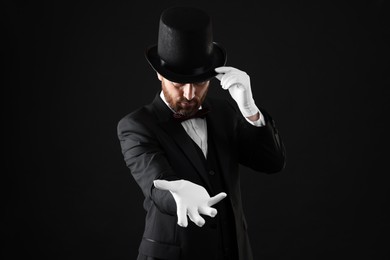 Photo of Magician in top hat on black background