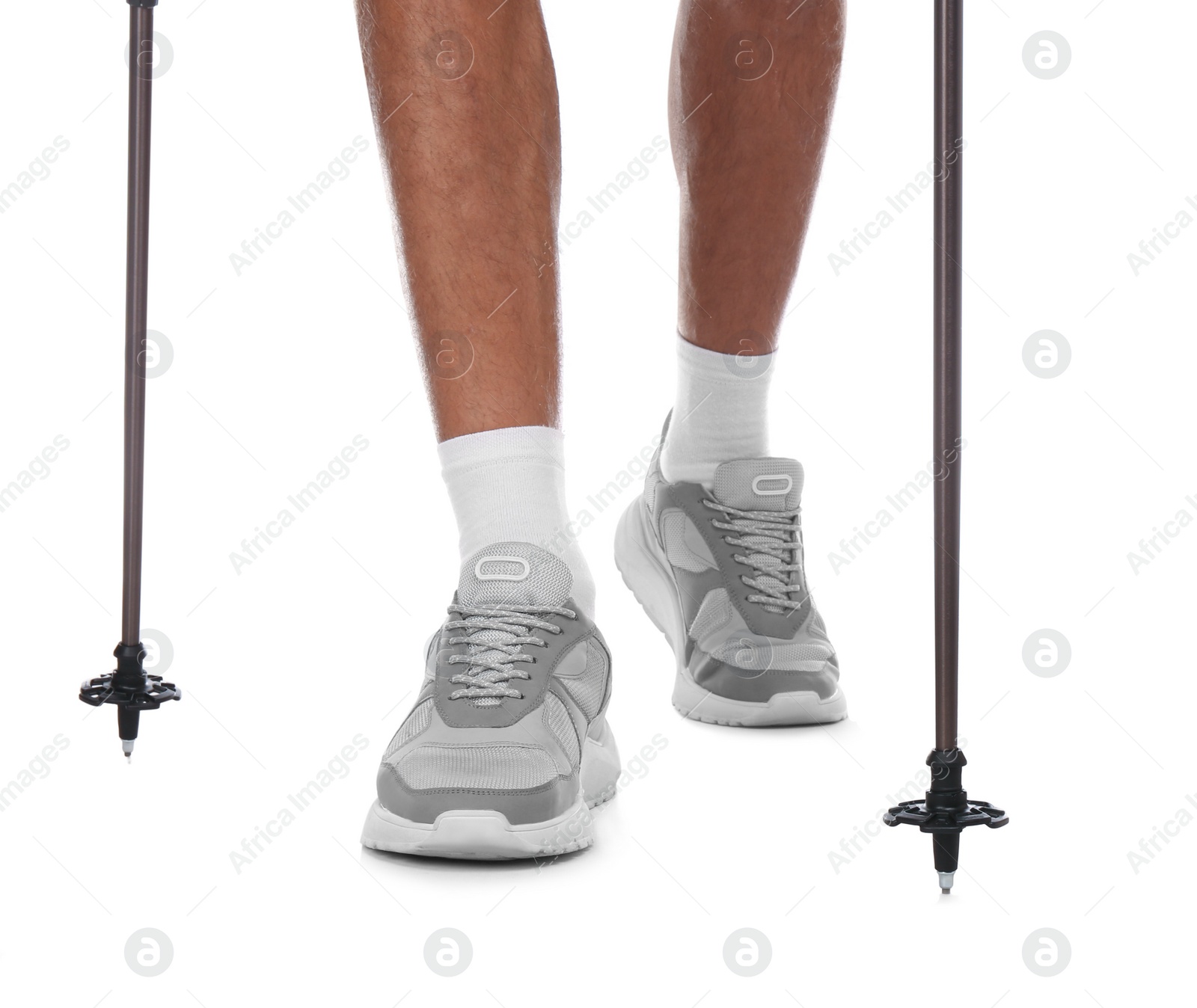 Photo of Man wearing stylish shoes with trekking poles on white background, closeup