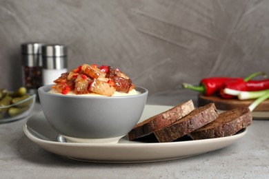 Potato puree and tasty fried cracklings on grey table. Cooked pork lard