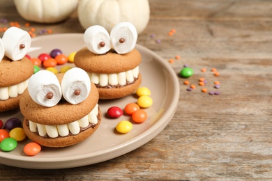 Photo of Delicious Halloween themed desserts on wooden table