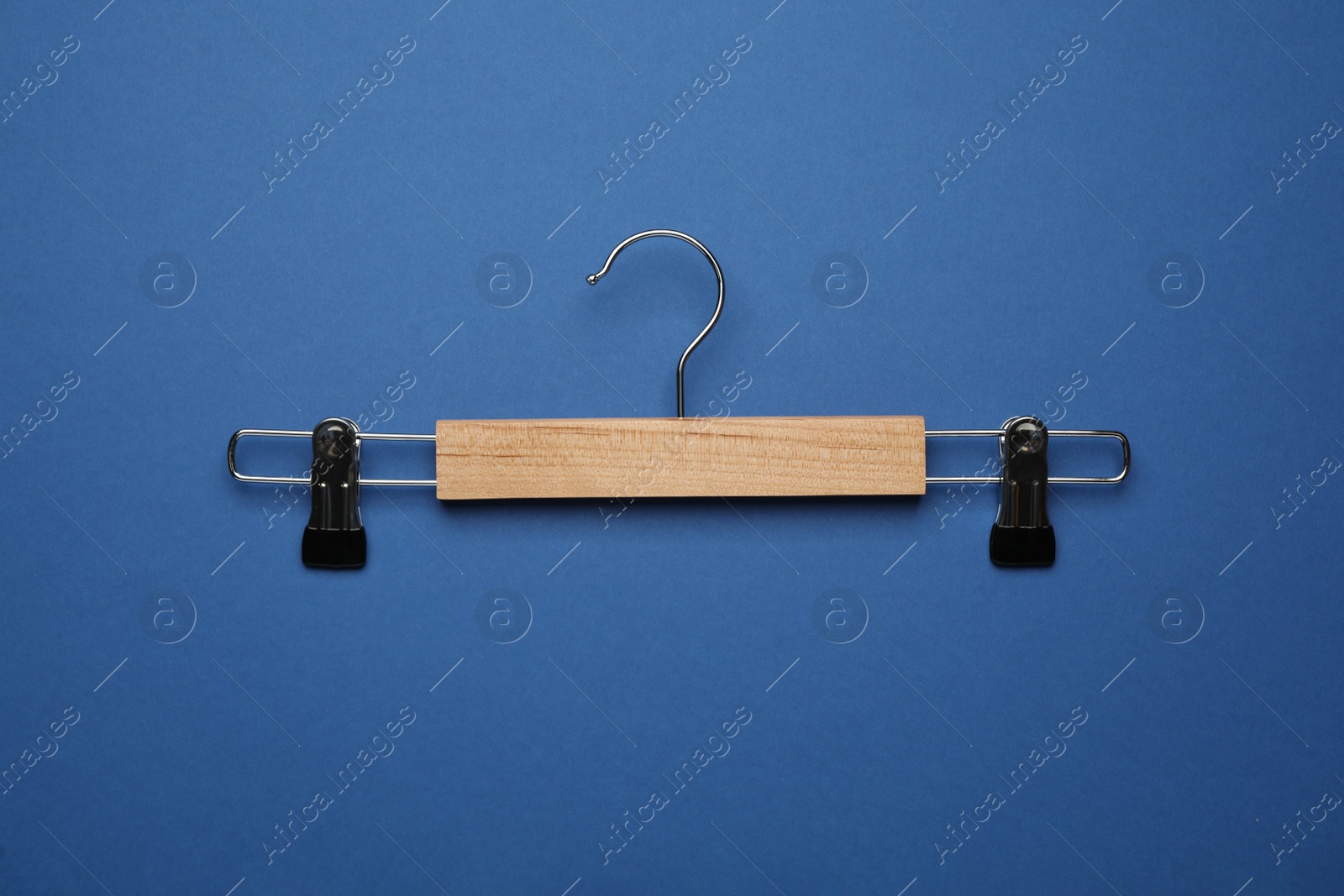 Photo of Empty clothes hanger on blue background, top view