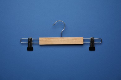 Empty clothes hanger on blue background, top view