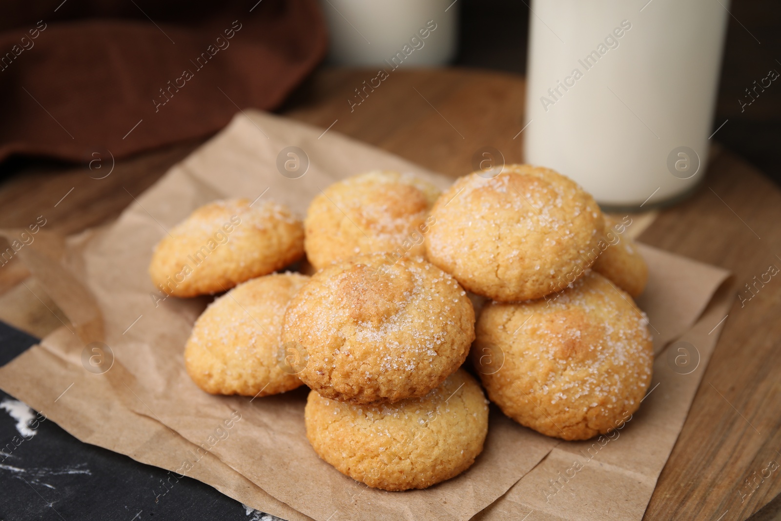 Photo of Tasty sweet sugar cookies and milk on wooden table, closeup