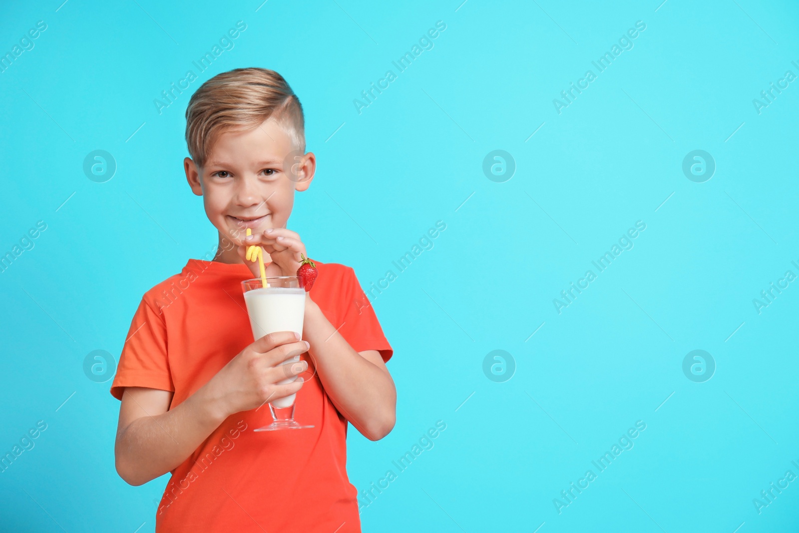 Photo of Little boy with glass of milk shake on color background