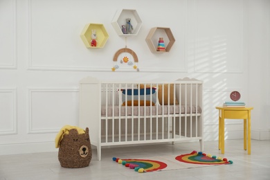 Cute baby room interior with comfortable crib and toys