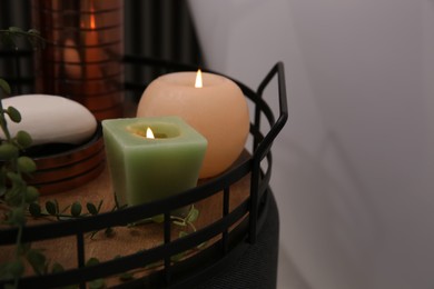 Photo of Burning candles and soap on tray, closeup view