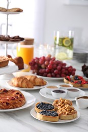 Variety of snacks on white marble table in buffet style indoors