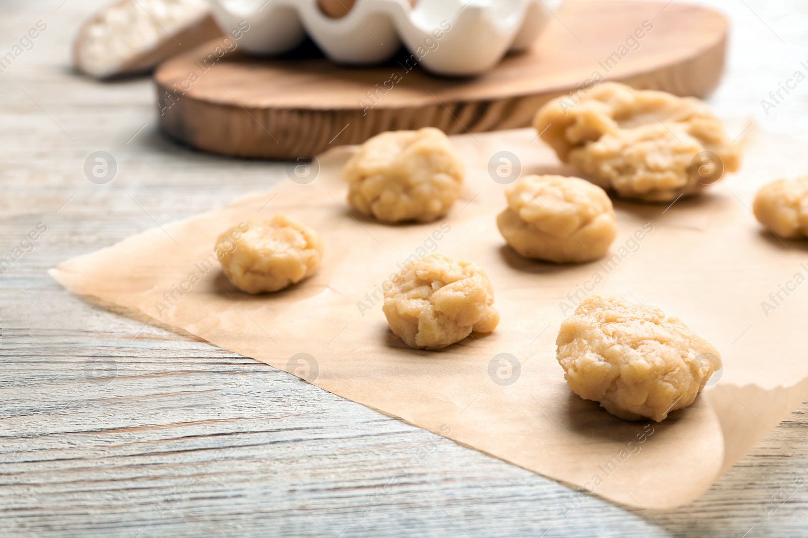 Photo of Pieces of fresh raw dough on wooden table