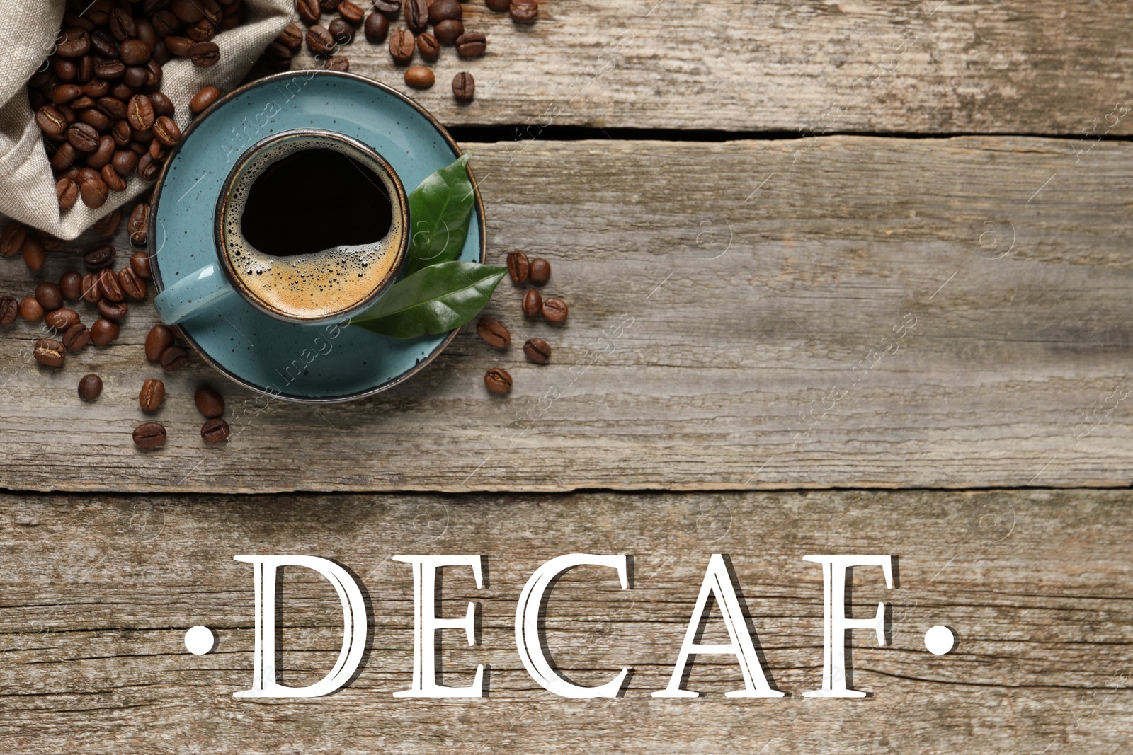 Image of Cup of aromatic decaf coffee and beans on wooden table, flat lay