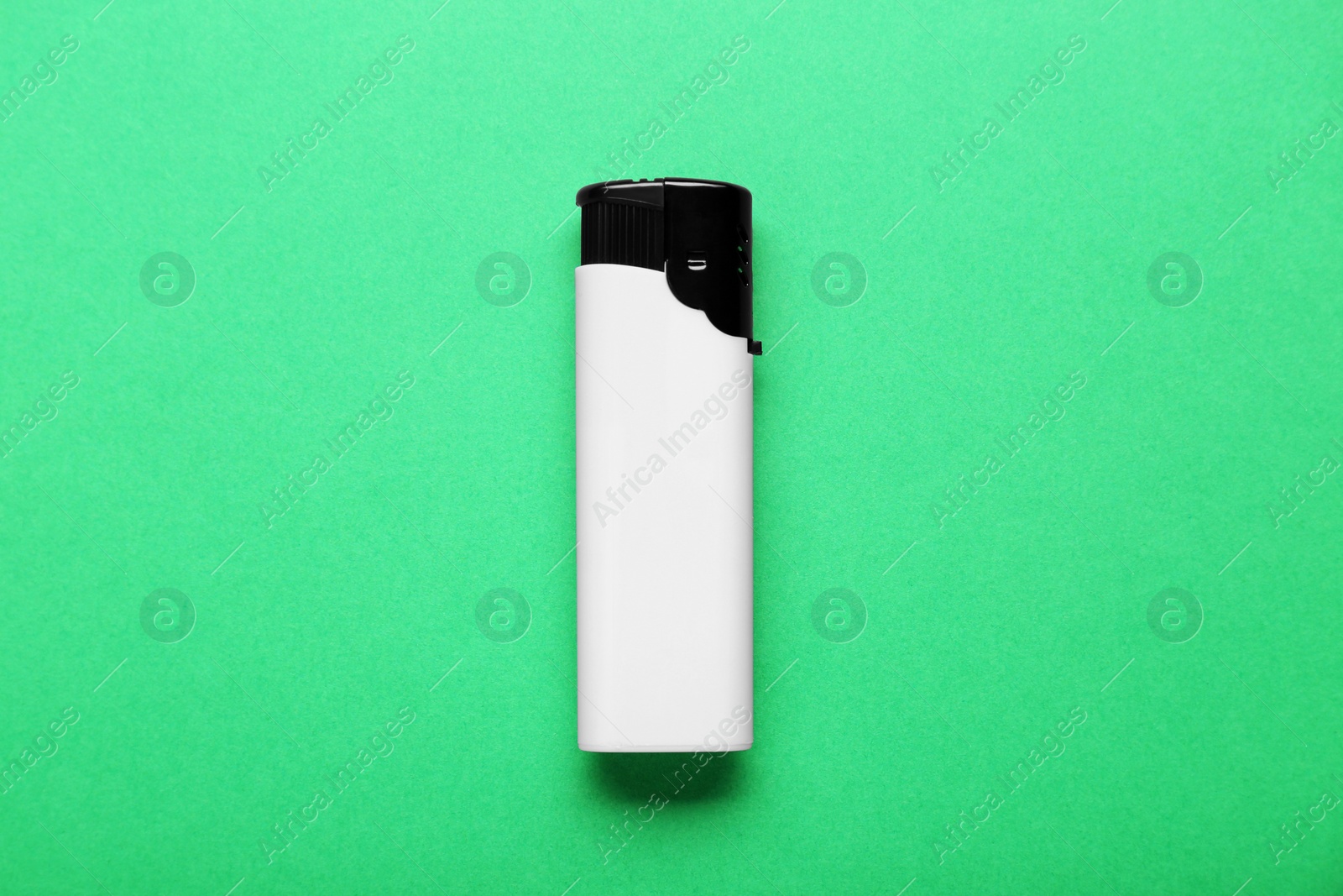 Photo of Stylish small pocket lighter on green background, top view