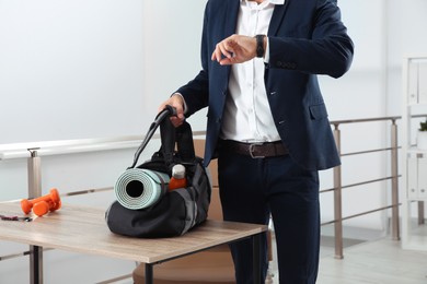 Businessman with sports bag in office, closeup