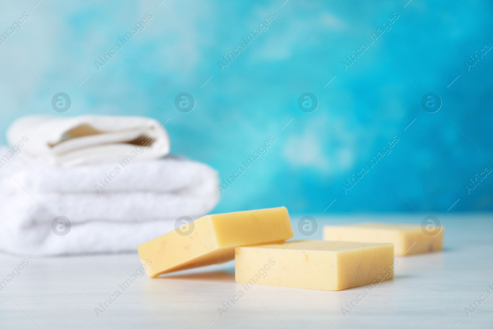 Photo of Handmade soap bars on table against color background. Space for text