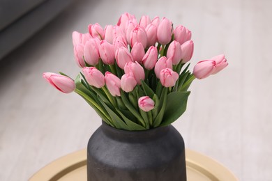 Photo of Bouquet of beautiful pink tulips in vase on table indoors