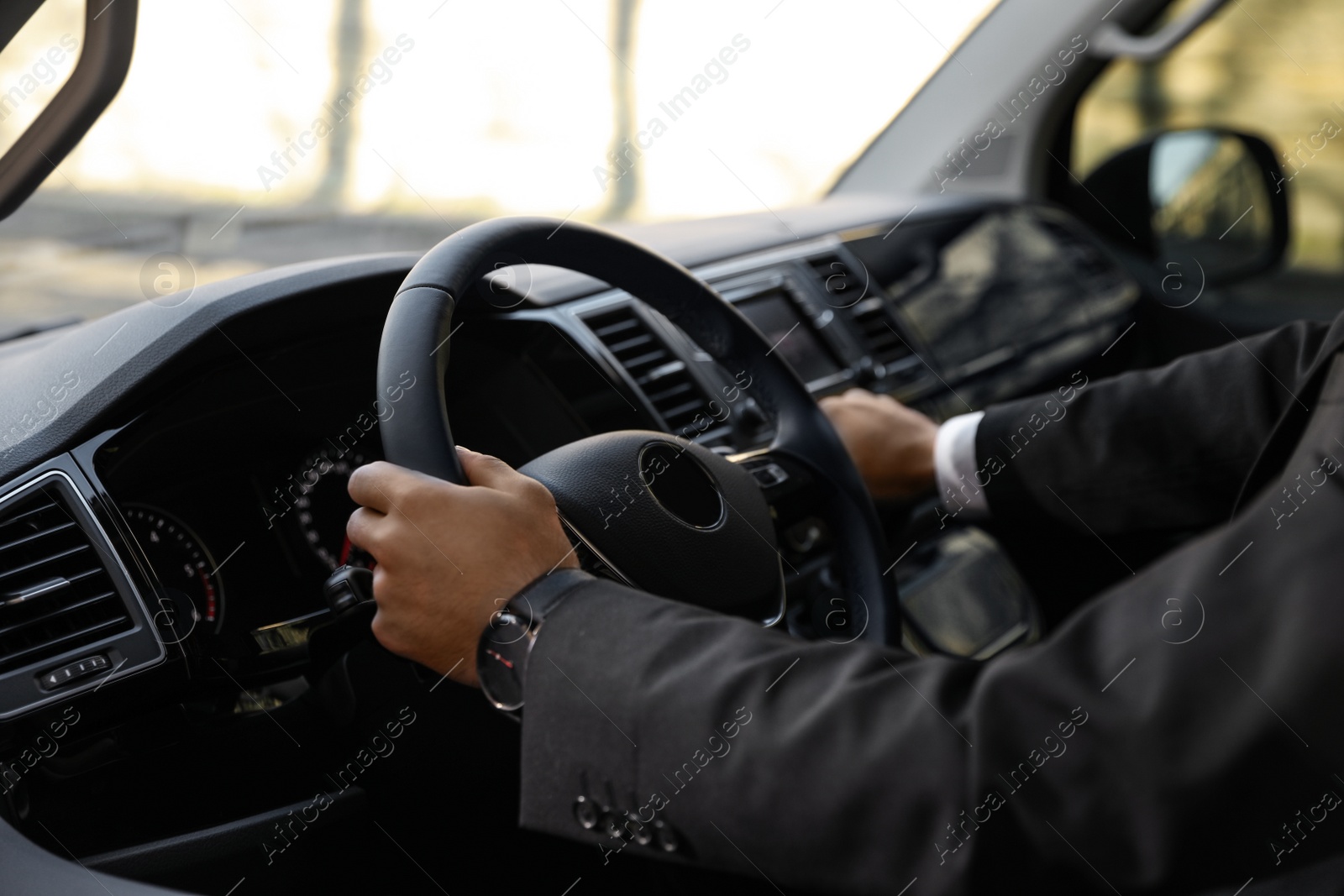 Photo of Professional driver in luxury car, closeup. Chauffeur service