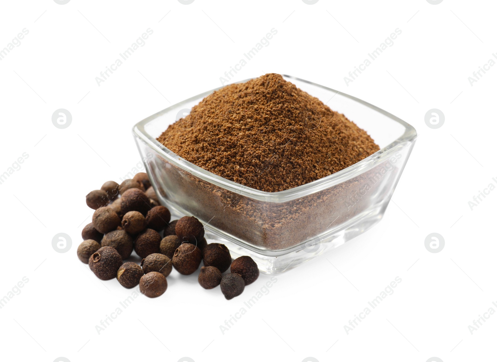 Photo of Ground allspice pepper in glass bowl and grains isolated on white