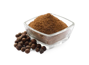 Ground allspice pepper in glass bowl and grains isolated on white