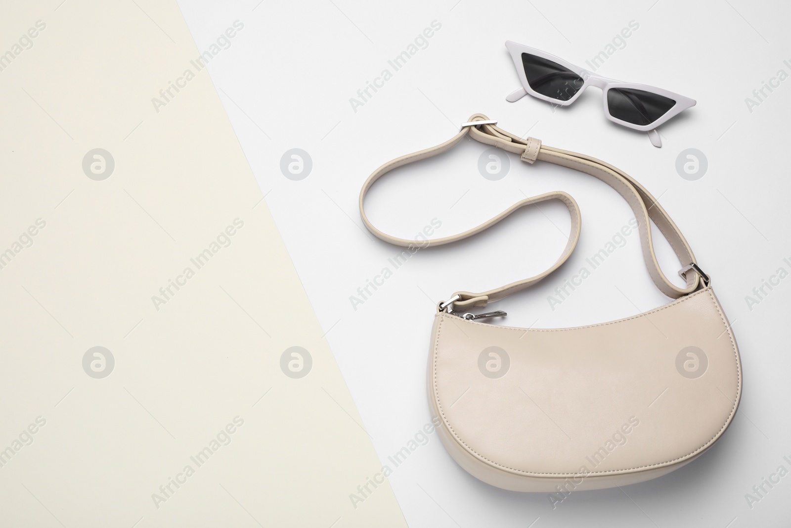 Photo of Stylish women's bag and sunglasses on color background, flat lay. Space for text