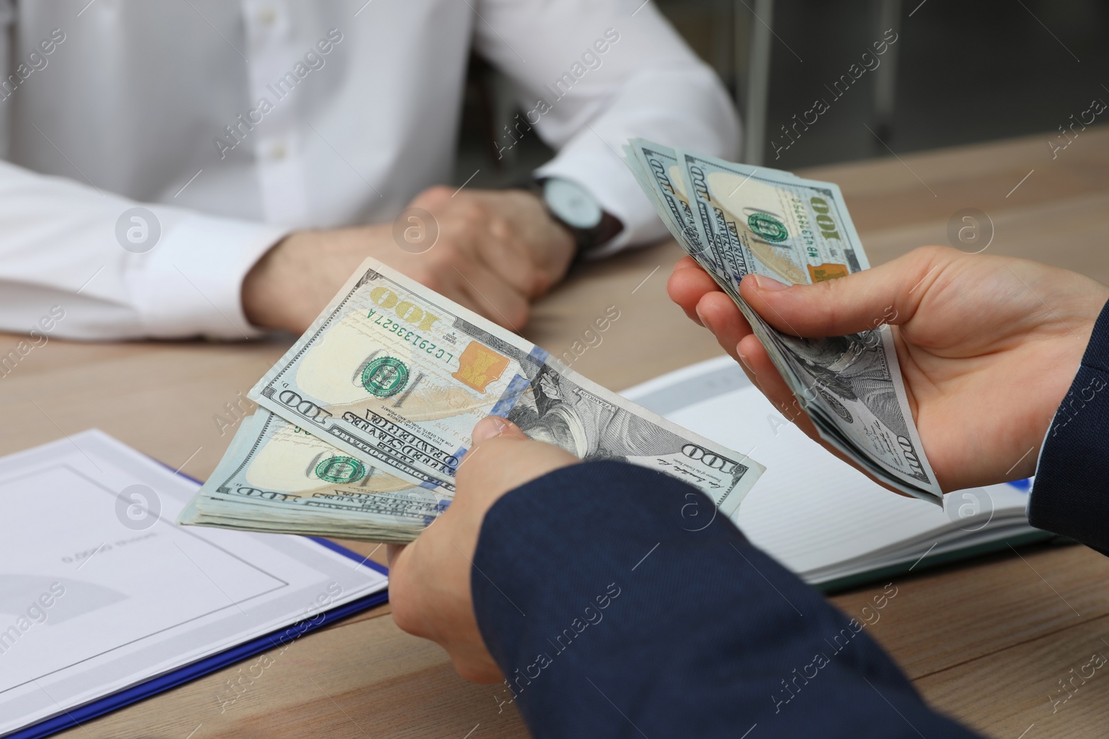 Photo of Cashier counting money at desk in bank, closeup