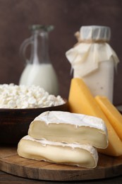 Photo of Dairy products. Milk and different kinds of cheese on wooden table, closeup