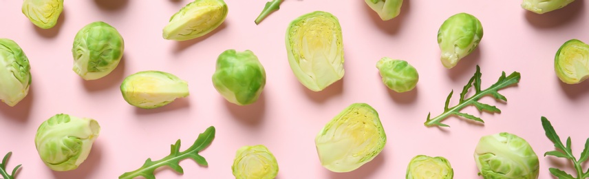 Fresh Brussels sprouts and arugula on color background, flat lay