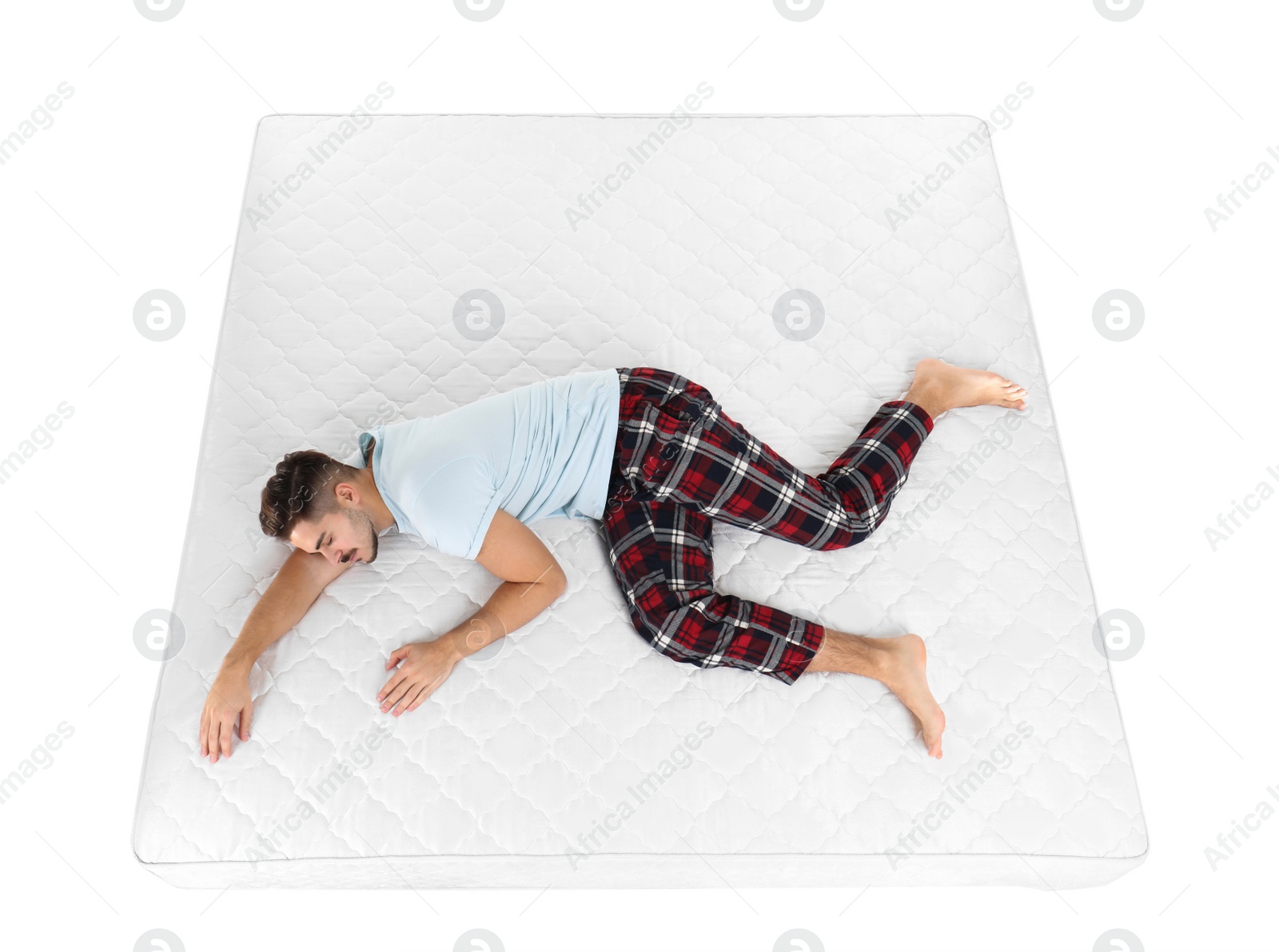 Photo of Young man sleeping on mattress against white background, above view