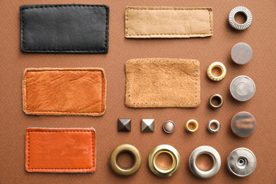 Photo of Flat lay composition with garment accessories for jeans on brown background