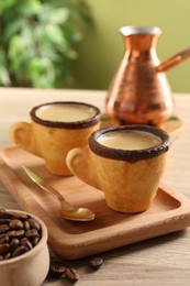 Delicious edible biscuit cups with espresso, spoon and board near coffee beans on wooden table