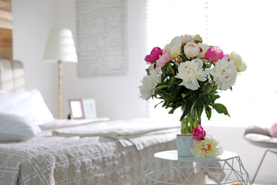 Photo of Beautiful blooming peonies on table in bedroom. Space for text