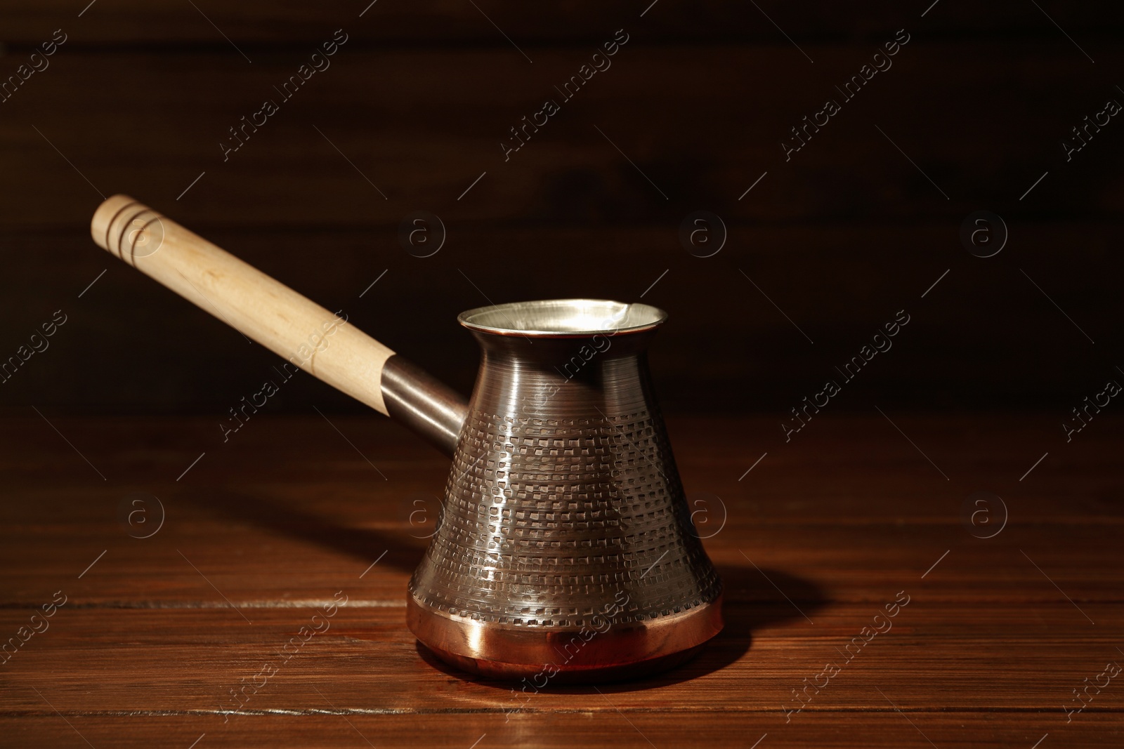 Photo of Beautiful copper turkish coffee pot on wooden table