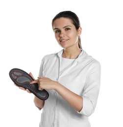 Photo of Beautiful female orthopedist showing insole on white background