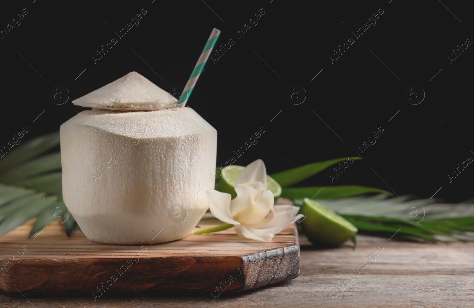 Photo of Fresh coconut drink in nut on wooden board