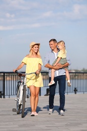 Photo of Happy family with bicycle outdoors on sunny day