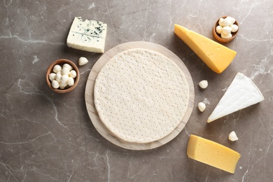 Flat lay composition with pizza crust and fresh ingredients on table