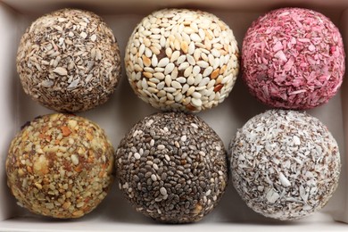 Photo of Different delicious vegan candy balls in box, top view