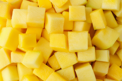 Many delicious mango cubes as background, closeup