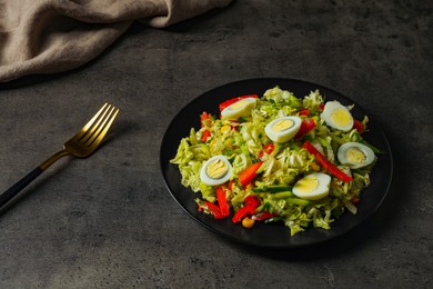 Photo of Delicious salad with Chinese cabbage and quail eggs served on black table