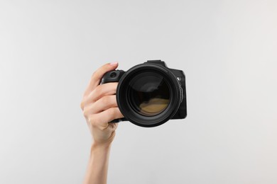 Photo of Photographer with camera on light grey background, closeup