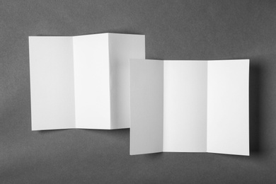 Photo of Blank brochures on gray background, view from above. Mock up for design