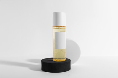 Photo of Bottle of cosmetic product and round podiums on white background