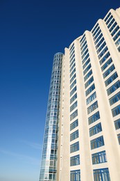 Beautiful skyscraper against blue sky on sunny day, low angle view