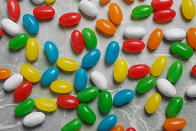 Flat lay composition with delicious jelly beans on stone background